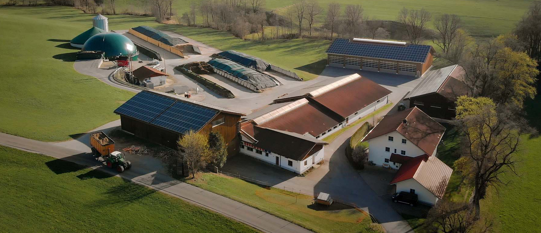 Gewerbespeicher, Luftbild eines Bauernhofs mit Wohnhaus, mehreren Ställen und Schäunen, Lagerflächen und Biogasanlage. Viele Dachflächen sind mit Solarmodulen belegt. Foto: SMA 